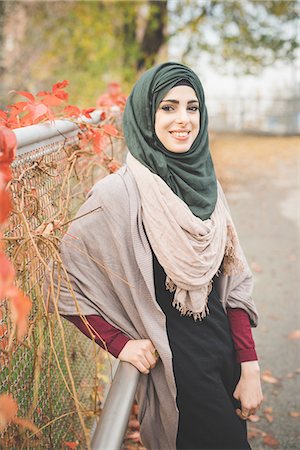 religious portraits - Portrait of young woman leaning against railing on park path Stock Photo - Premium Royalty-Free, Code: 649-08086482