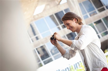 person holding a camera - Student photographer taking picture Stock Photo - Premium Royalty-Free, Code: 649-08086532