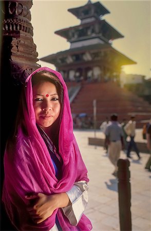 Portrait of young Nepalese woman sitting outside temple, Kathmandu, Nepal Stock Photo - Premium Royalty-Free, Code: 649-08086773