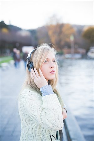 Young woman looking up whilst listening to headphones on lakeside, Como, Italy Foto de stock - Sin royalties Premium, Código: 649-08086817