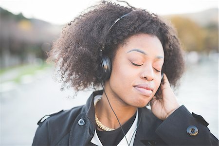 simsearch:649-08086803,k - Close up of young woman listening to headphones with eyes closed at Lake Como, Italy Fotografie stock - Premium Royalty-Free, Codice: 649-08086822