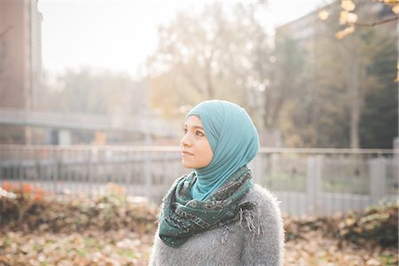 Portrait of young woman wearing hijab gazing in park Stock Photo - Premium Royalty-Free, Code: 649-08086840