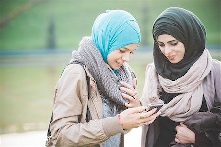 Two young women at lakeside texting on smartphone Foto de stock - Sin royalties Premium, Código: 649-08086855