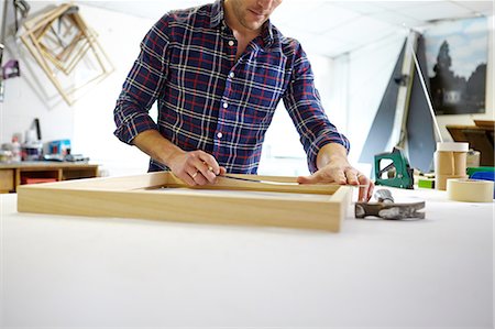 régua - Mid adult man measuring frame on workbench in picture framers workshop Foto de stock - Royalty Free Premium, Número: 649-08086959