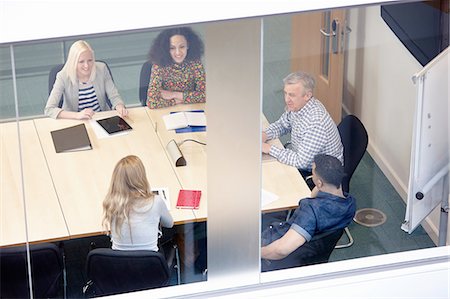 simsearch:649-08118758,k - High angle view of businessmen and women having meeting at conference table Stock Photo - Premium Royalty-Free, Code: 649-08117806