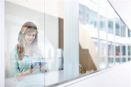 shallow depth of field - Businesswoman using digital tablet behind office window Stock Photo - Premium Royalty-Free, Code: 649-08117800