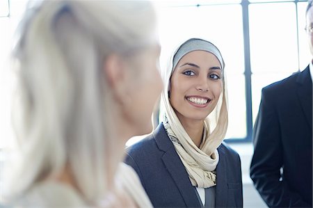 simsearch:649-07436569,k - Over shoulder view of businesswomen chatting in office Photographie de stock - Premium Libres de Droits, Code: 649-08117894