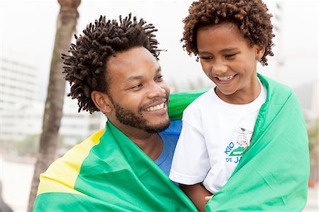 Father and son wrapped in Brazilian flag on Ipanema beach, Rio De Janeiro, Brazil Stock Photo - Premium Royalty-Free, Code: 649-08118005