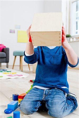 Boy covering face with wooden box Stock Photo - Premium Royalty-Free, Code: 649-08118134