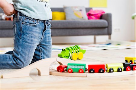 debajo de la cintura - Girl playing with toy cars at home Foto de stock - Sin royalties Premium, Código: 649-08118132