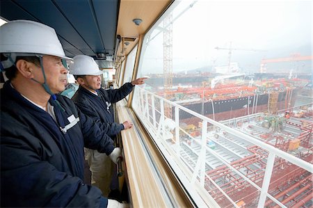 Workers having discussion overlooking shipping port, GoSeong-gun, South Korea Stock Photo - Premium Royalty-Free, Code: 649-08118248