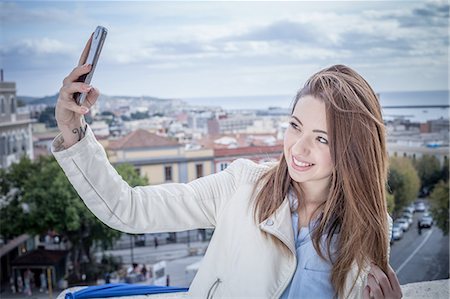 sardinia - Young woman on rooftop taking smartphone selfie, Cagliari, Sardinia, Italy Photographie de stock - Premium Libres de Droits, Code: 649-08118448