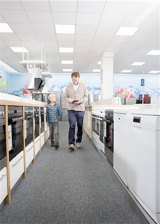 family shopping not groceries - Male shopper and son checking prices on digital tablet in electronics store Foto de stock - Sin royalties Premium, Código: 649-08118538