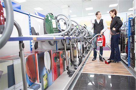 simsearch:649-07064068,k - Shop assistant demonstrating vacuum cleaner in electronics store Stock Photo - Premium Royalty-Free, Code: 649-08118532