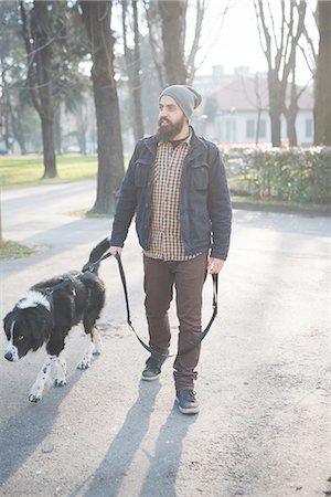 simsearch:649-08118579,k - Mid adult man walking dog through park Stock Photo - Premium Royalty-Free, Code: 649-08118573