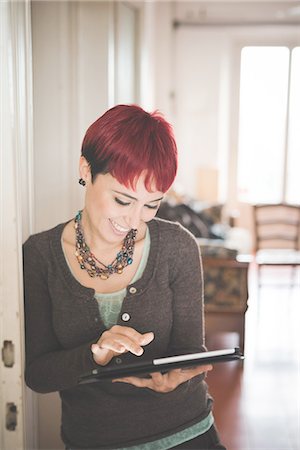 Young woman at home using digital tablet Stock Photo - Premium Royalty-Free, Code: 649-08118605