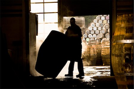 Silhouette of man working in cooperage with whisky cask Photographie de stock - Premium Libres de Droits, Code: 649-08118618