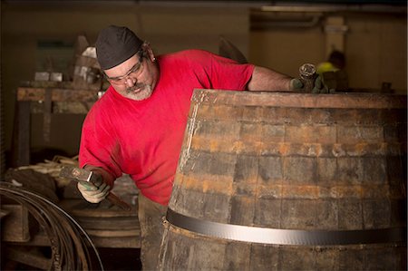 scottish culture - Male cooper using hammer in cooperage with whisky casks Stock Photo - Premium Royalty-Free, Code: 649-08118613