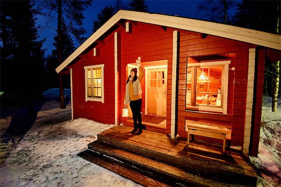 Young woman looking out from cabin porch at night, Posio, Lapland, Finland Stock Photo - Premium Royalty-Free, Image code: 649-08118778