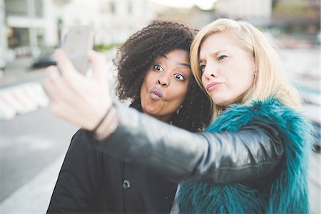 simsearch:649-08702811,k - Two young women pulling faces for smartphone selfie, Lake Como, Como, Italy Stock Photo - Premium Royalty-Free, Code: 649-08118791