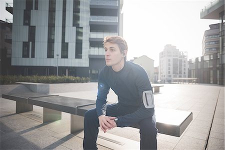 Young male runner taking a break on bench in city square Foto de stock - Sin royalties Premium, Código: 649-08118833