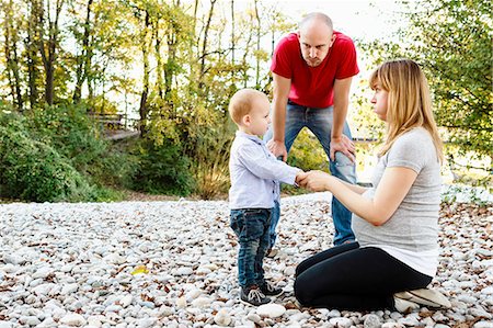 Son face to face with mother, holding hands, while father looks on Photographie de stock - Premium Libres de Droits, Code: 649-08118907