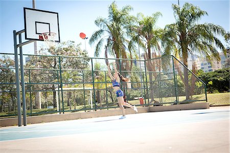 simsearch:614-07146671,k - Young woman on outdoor basketball court, throwing ball towards hoop Photographie de stock - Premium Libres de Droits, Code: 649-08118987