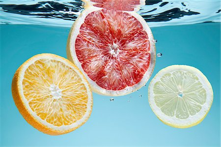 simsearch:649-08119132,k - Slices of pink grapefruit, orange and lemon underwater Photographie de stock - Premium Libres de Droits, Code: 649-08119135