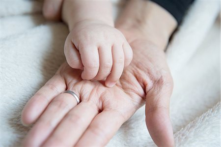 simsearch:614-02838643,k - Baby boy's hand resting on mother's hand, close-up Photographie de stock - Premium Libres de Droits, Code: 649-08119446
