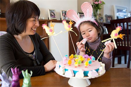 simsearch:400-09096062,k - Mother and daughter sitting at table, Easter cake in front of them Photographie de stock - Premium Libres de Droits, Code: 649-08125098