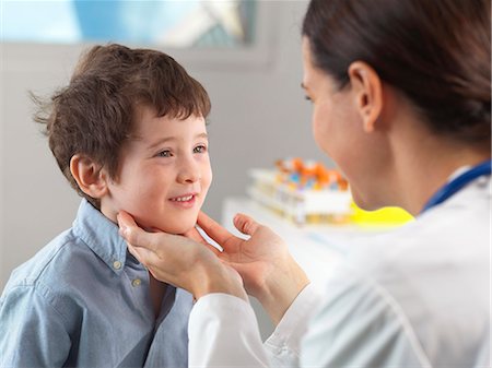 simsearch:649-08125163,k - Doctor checking glands of young boy in clinic Photographie de stock - Premium Libres de Droits, Code: 649-08125162