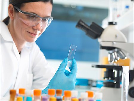 Scientist holding microscope slide with blood sample in lab Stock Photo - Premium Royalty-Free, Code: 649-08125189