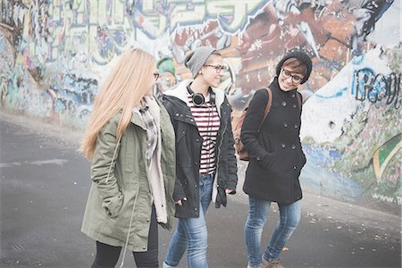 Three sisters walking by graffiti wall Stock Photo - Premium Royalty-Free, Code: 649-08125221