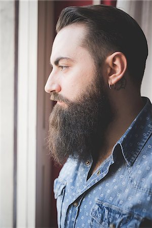 simsearch:649-08125262,k - Young bearded man looking out of window Photographie de stock - Premium Libres de Droits, Code: 649-08125273