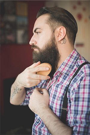 simsearch:649-08125285,k - Young bearded man brushing his beard Photographie de stock - Premium Libres de Droits, Code: 649-08125291