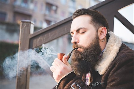 simsearch:649-08125310,k - Young bearded man smoking pipe on steps Foto de stock - Sin royalties Premium, Código: 649-08125311