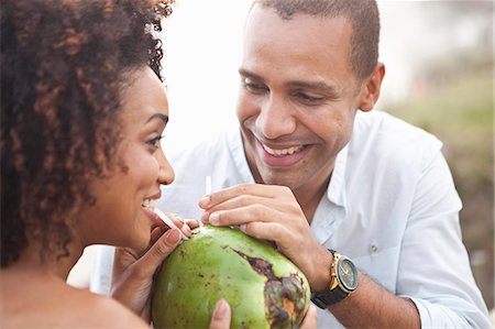 simsearch:649-08125388,k - Close up of couple sharing coconut milk at beach, Rio De Janeiro, Brazil Stock Photo - Premium Royalty-Free, Code: 649-08125389