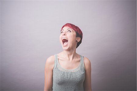 screaming portrait - Studio portrait of young woman with short pink hair shouting Stock Photo - Premium Royalty-Free, Code: 649-08125677