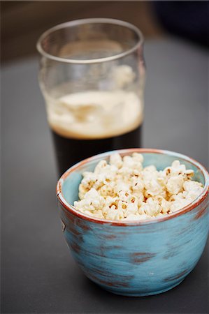 pipoca - Bowl of popcorn and pint of beer Foto de stock - Royalty Free Premium, Número: 649-08125742