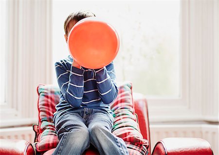 Young boy holding balloon in front of face Stock Photo - Premium Royalty-Free, Code: 649-08125802