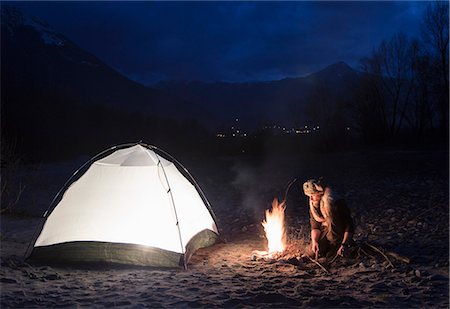 Man by campfire and tent at night Stock Photo - Premium Royalty-Free, Code: 649-08125839