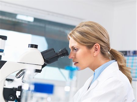 Scientist viewing sample on glass slide through microscope for medical testing Photographie de stock - Premium Libres de Droits, Code: 649-08125921