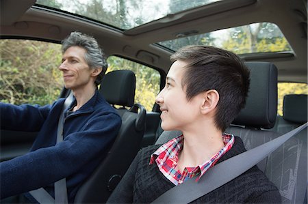 Teenage boy looking at father whilst he drives car Stock Photo - Premium Royalty-Free, Code: 649-08125958