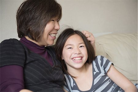 simsearch:614-07587666,k - Smiling girl and her mother sitting on sofa Stock Photo - Premium Royalty-Free, Code: 649-08125965