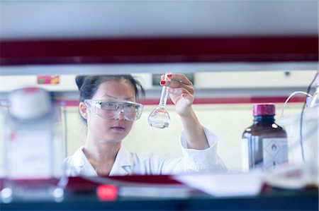 Young female scientist  holding up volumetric flask in lab Stock Photo - Premium Royalty-Free, Code: 649-08126040