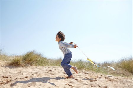 simsearch:649-08144203,k - Young boy flying kite on beach Photographie de stock - Premium Libres de Droits, Code: 649-08144195