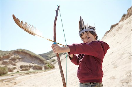 simsearch:649-07761116,k - Young boy wearing fancy dress, holding home-made bow and arrow Fotografie stock - Premium Royalty-Free, Codice: 649-08144208