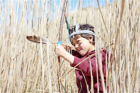 Young boy wearing fancy dress, holding home-made bow and arrow Stock Photo - Premium Royalty-Free, Code: 649-08144211