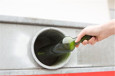 recycle center - Person recycling wine bottle in bottle bank Stock Photo - Premium Royalty-Free, Code: 649-08144294