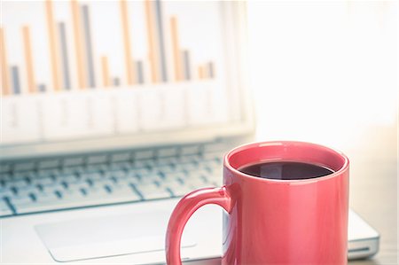 stock exchange - Close up still life of black coffee and bar finance chart on laptop screen Foto de stock - Sin royalties Premium, Código: 649-08144347